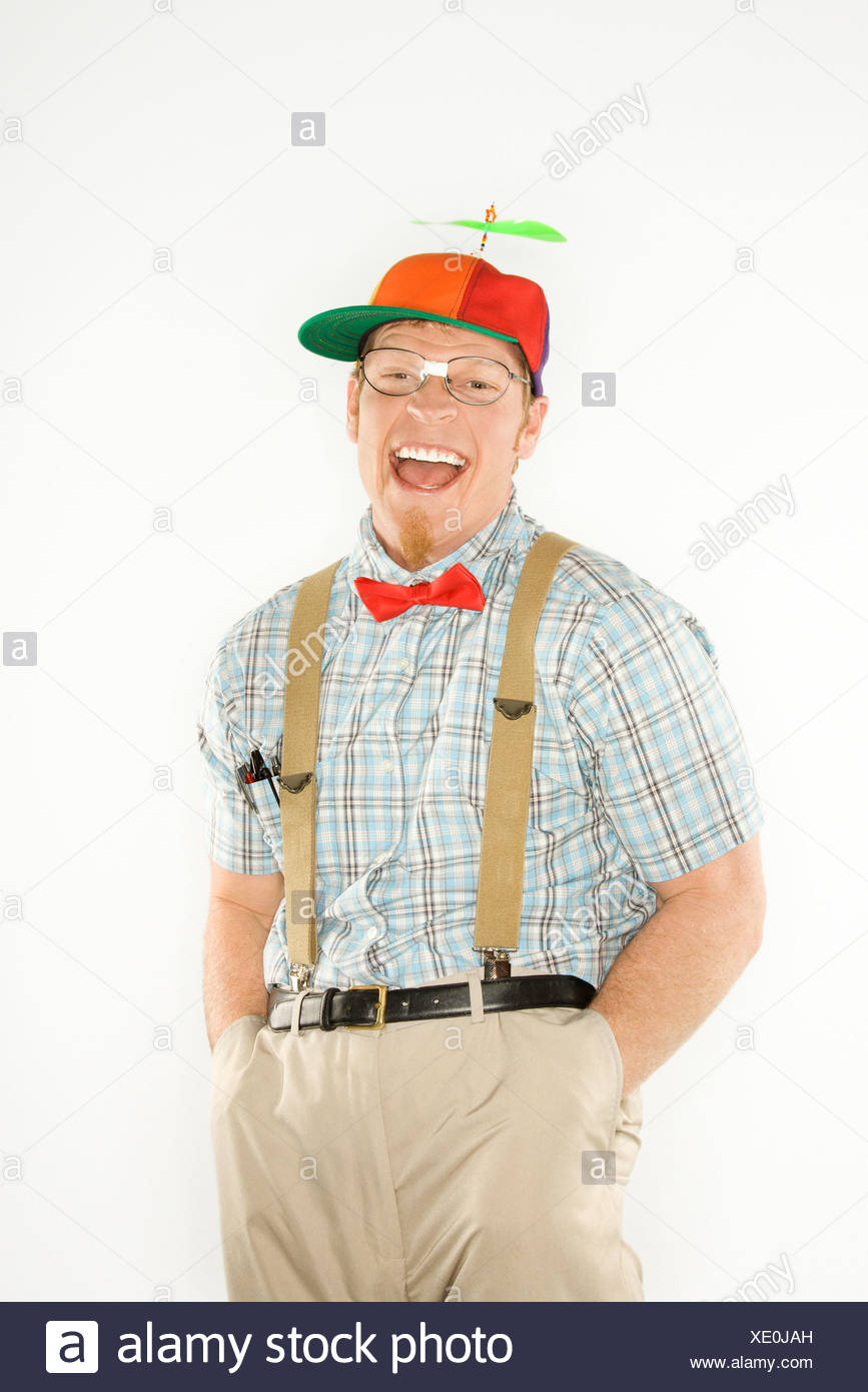 caucasian-young-man-dressed-like-nerd-wearing-propeller-cap-with-hands-in-pockets-looking-at-viewer-with-big-smile-XE0JAH.jpg